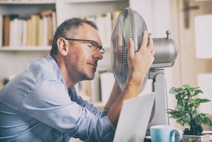 Man in front of fan